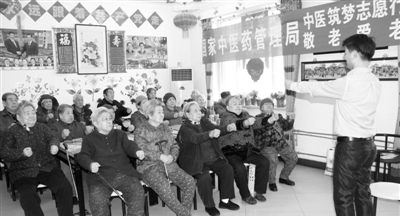 图为中国中医科学院专家代金刚在教授老年人中医养生保健操