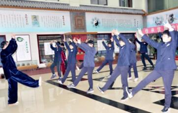 图为杨玉民带领中学生练习五禽戏