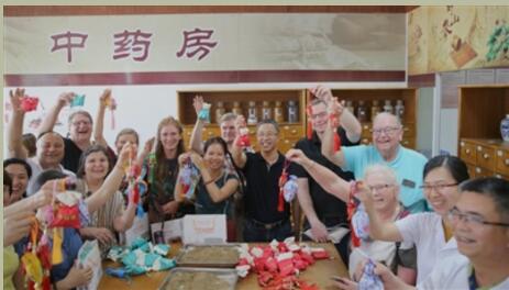 图为参访团成员展示亲手制作的药香囊